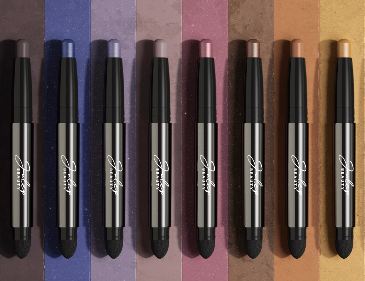 A row of eyeshadow sticks on a colored background