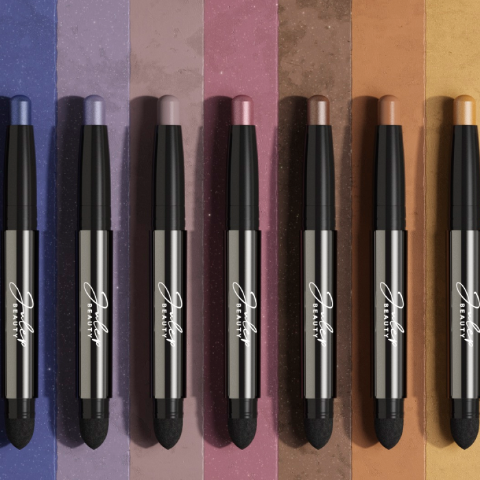 A row of eyeshadow sticks on a colored background